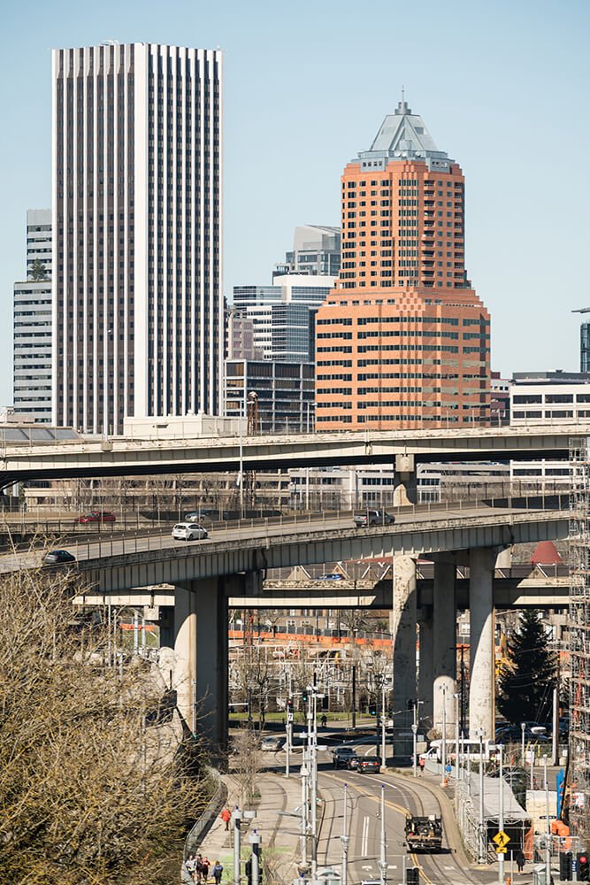a bridge over a river with a city in the background