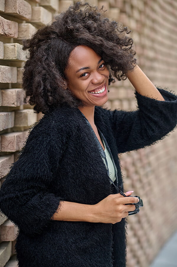 a person smiling and wearing a black sweater